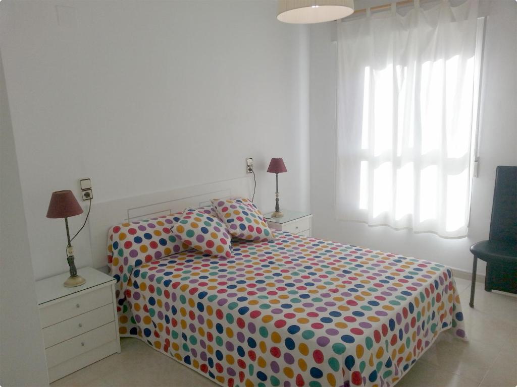 a bedroom with a bed with a colorful comforter at Acogedor apartamento en el Casco Historico in Jávea