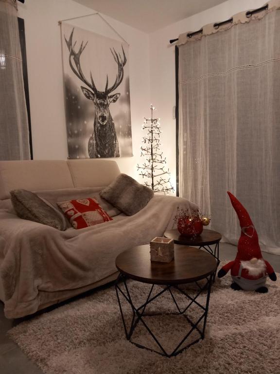 a living room with a bed and a deer picture at Gîtes les COMBES in Saint-Léger-les-Mélèzes