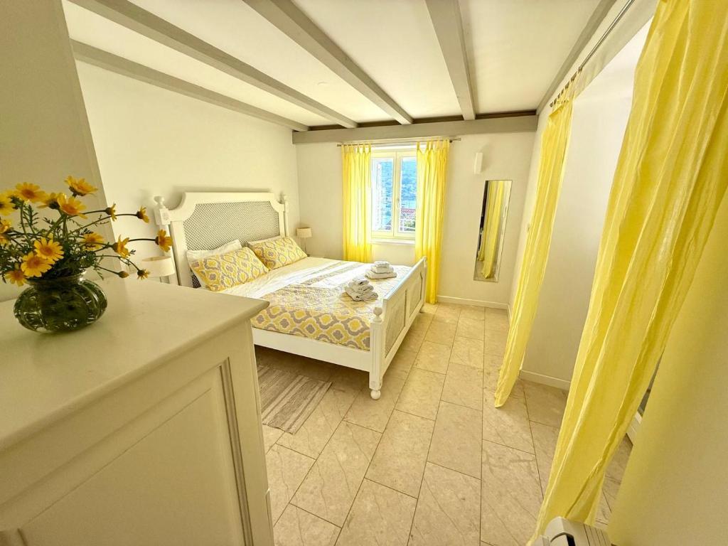a bedroom with a white bed and a window at JASMINE DELUXE APARTMENT with super-king bed, large sun terrace and spectacular views in Vis