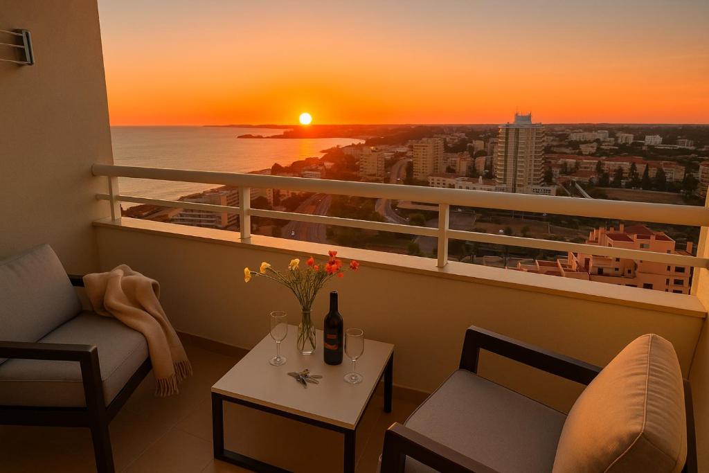 a room with a balcony with a sunset at Beachfront Premium Apartment with Sunset, Pools & Sea View in Portimão
