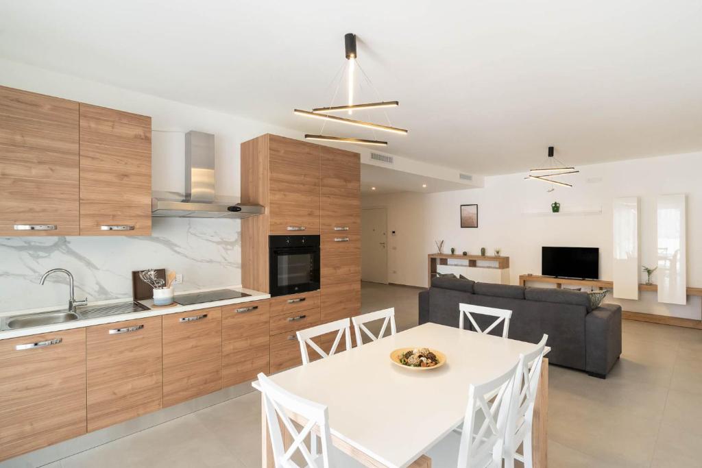 a kitchen and living room with a white table and chairs at Dimore Rosselli Suites in Fasano