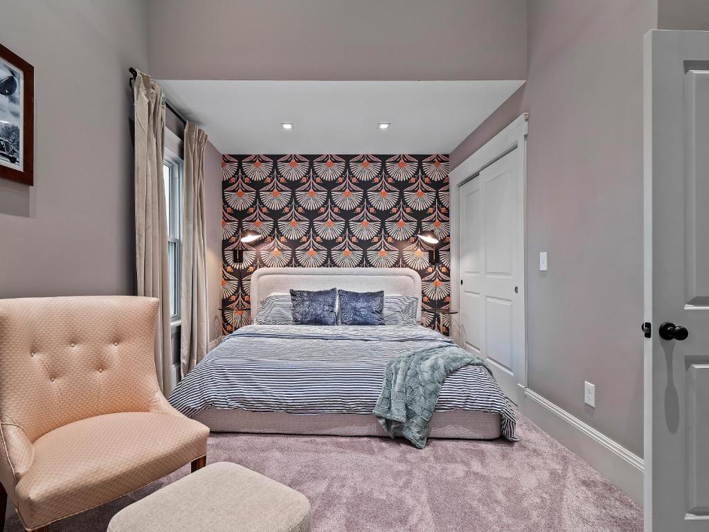 a bedroom with a bed and a chair at Cleveland Escape - Hot Tub - Karaoke Machine - Sleeps 12 in Cleveland