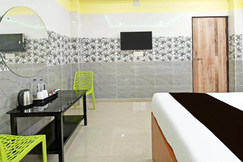 ブバネーシュワルにあるHotel O Dreams Lodgeのベッド、机、テレビのある寝室