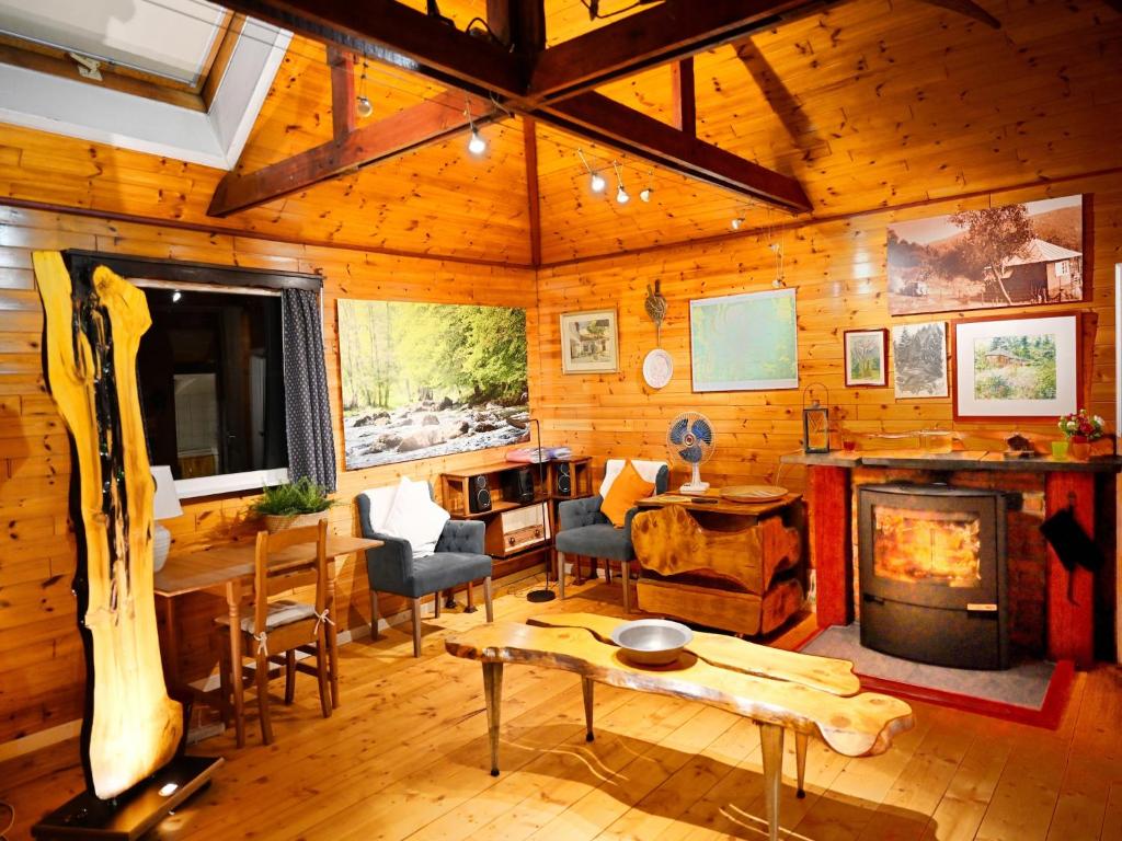 a living room with a fireplace in a log cabin at Vintage chalet in a very beautiful landscape in Aywaille