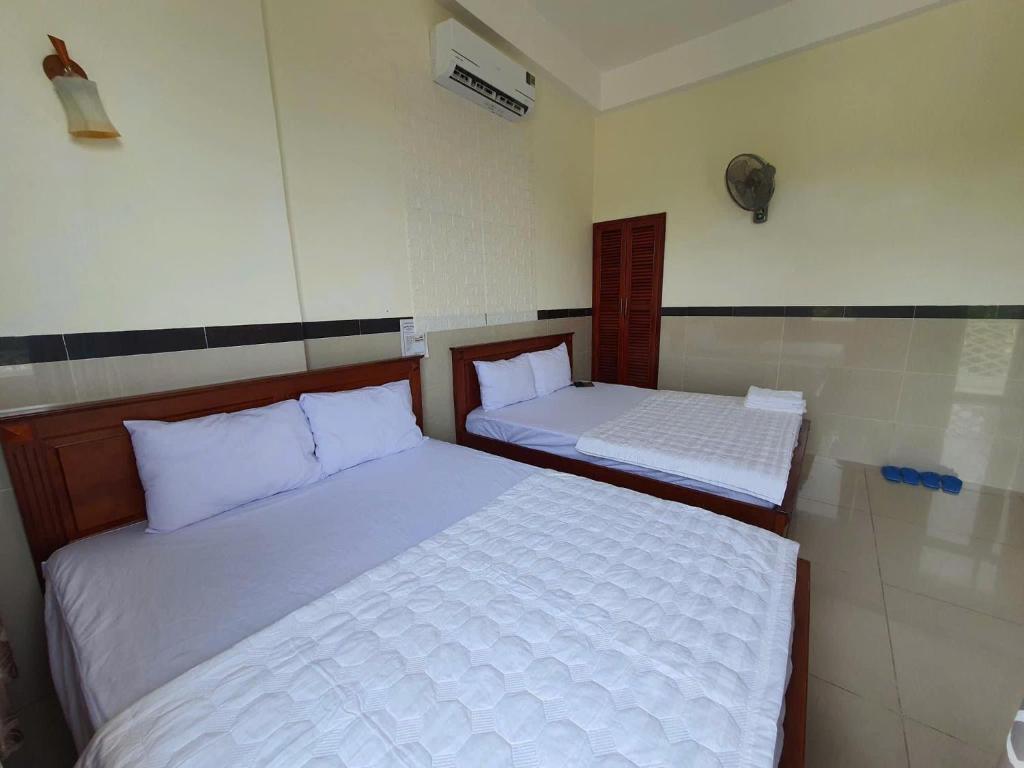 two beds in a small room with at Motel Bờ Kè in Bà Rịa