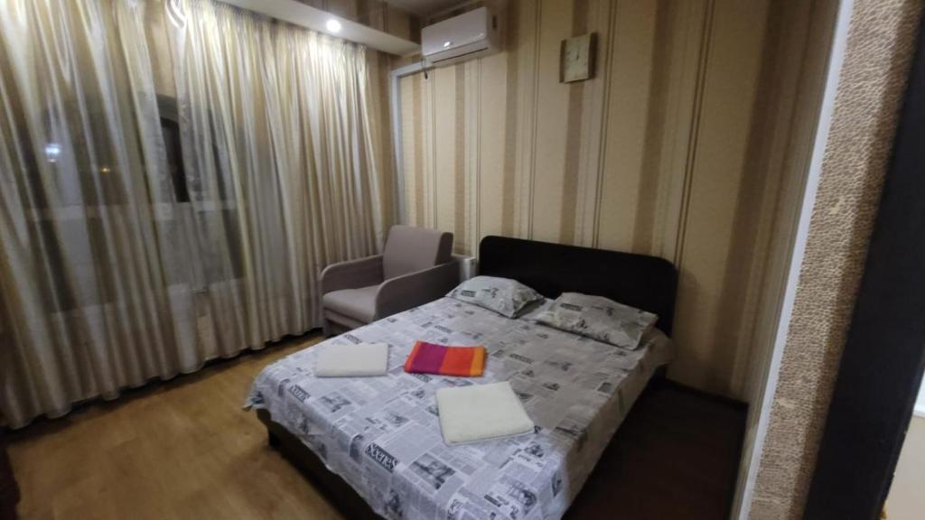 ein kleines Schlafzimmer mit einem Bett und einem Stuhl in der Unterkunft Apartment in the city centr Bursatsky descent in Kharkov