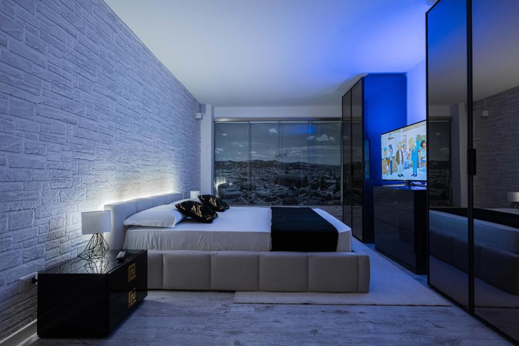 a bedroom with a large bed and a tv at Gramsci Prestige Apartment in Bologna