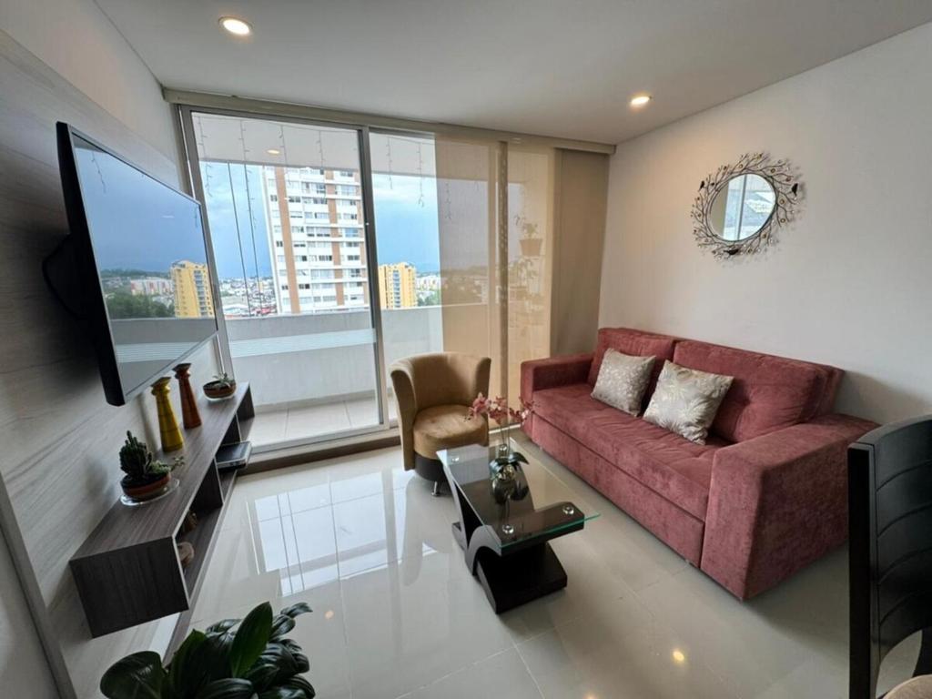 a living room with a red couch and a large window at Club house 1105-Apartamento Fundadores con balcón, piscina, gym in Armenia