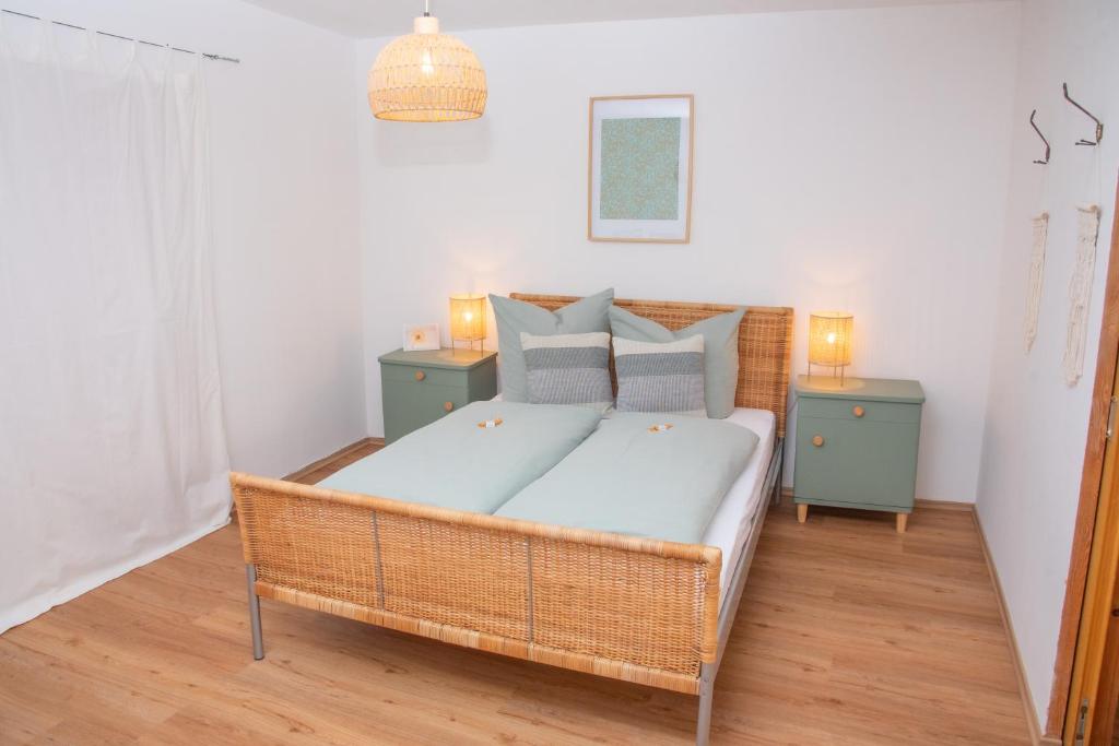 a bedroom with a wicker bed with two night stands at Gemütlich gestaltetes, familiengeführtes Apartment mit Burgblick in Burghausen