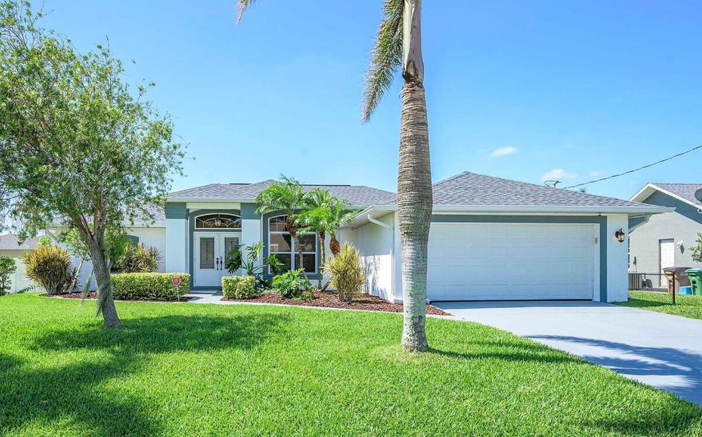 ein Haus mit einer Garage und einer Palme in der Unterkunft Blue Fish - Cozy vacation rental in Cape Coral in Matlacha