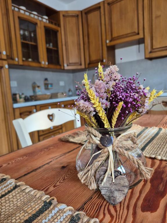 eine Blumenvase auf einem Holztisch in der Unterkunft Appartamento in struttura indipendente Appartamenti di Mezzo in Cecino
