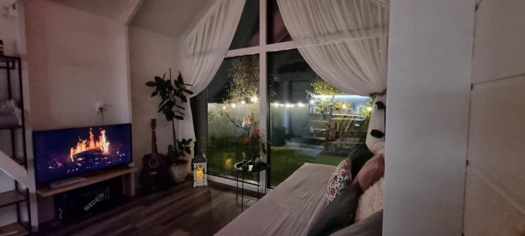 a living room with a fireplace and a tv at Namiņš atpūtai in Liepāja
