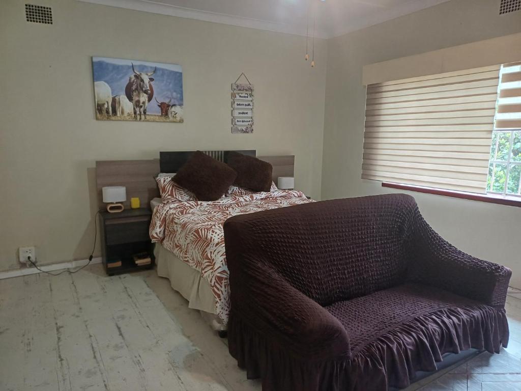a bedroom with a bed and a chair at Serene on 5 Cologne in Germiston
