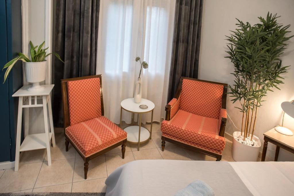 a room with two chairs and a table with plants at City Central Apartment with Parking in Larisa