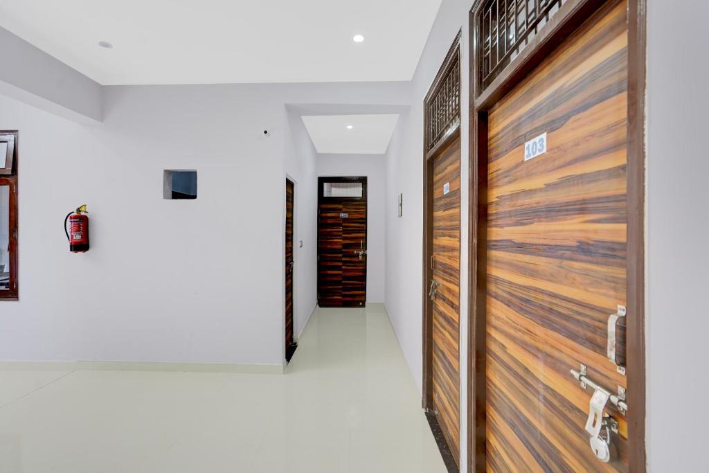 einen Flur mit Holztüren in einem Haus in der Unterkunft SPOT ON Samrat Hotel in Kānpur