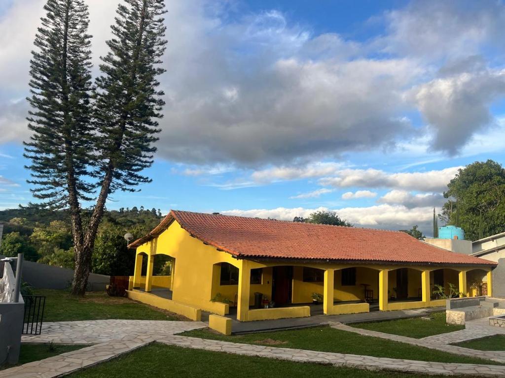 a small yellow building with a red roof at Chácara piscina aquecida in Juazeiro do Norte