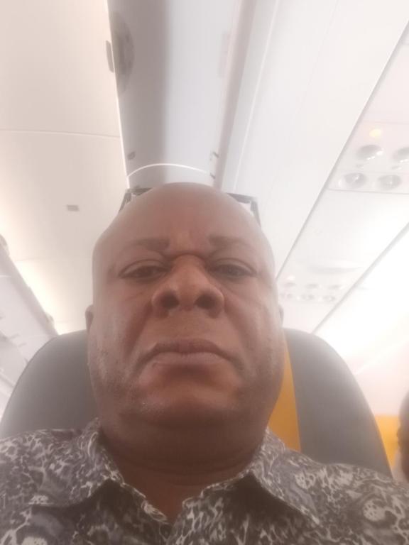 Ein Mann, der mit einem Hut auf dem Kopf in einem Flugzeugsitz sitzt in der Unterkunft Timothee in Cornellà de Llobregat