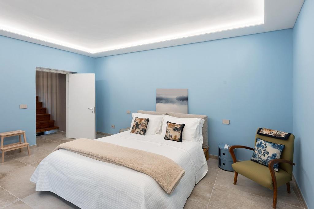 una camera da letto blu con un letto e una sedia di Civico 34 a Salerno