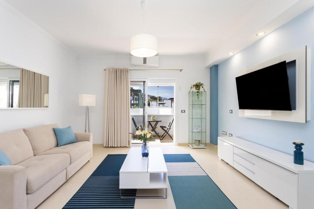 ein Wohnzimmer mit Sofa und Fernseher in der Unterkunft Brisa - Armonía Park, Bajamar in El Puertito