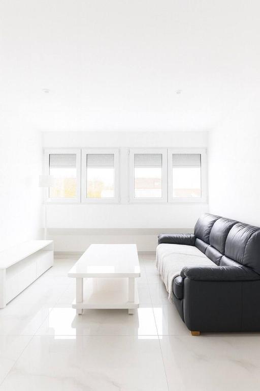 ein Wohnzimmer mit einem schwarzen Sofa und einem weißen Tisch in der Unterkunft DeLuxe Studio Lumineux, Rénové, Parking Gratuit, MULHOUSE CENTRE in Mulhouse