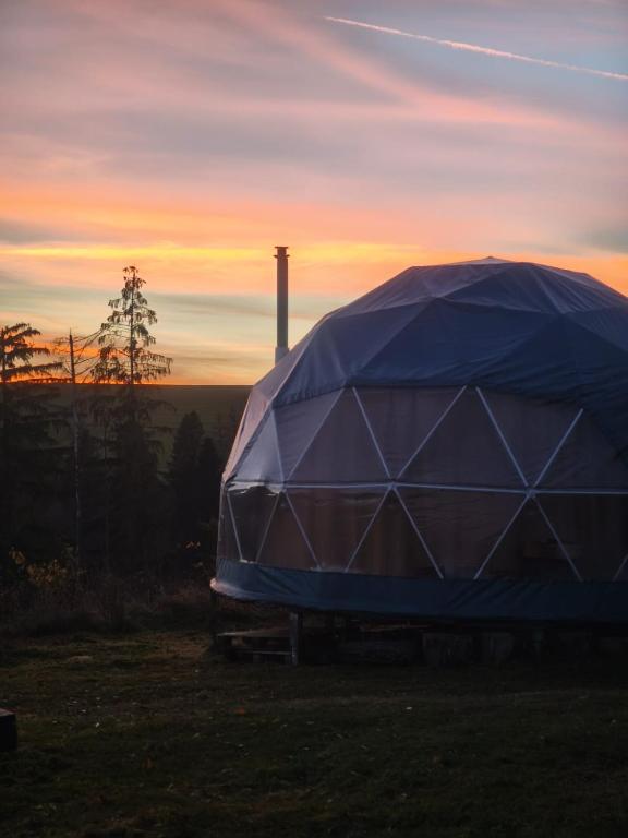 a dome tent sitting in a field at sunset at Wild Glamping Liptov in Liptovský Ondrej