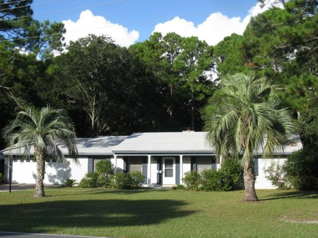 a white house with two palm trees in front of it at Hollybourne II in Jekyll Island
