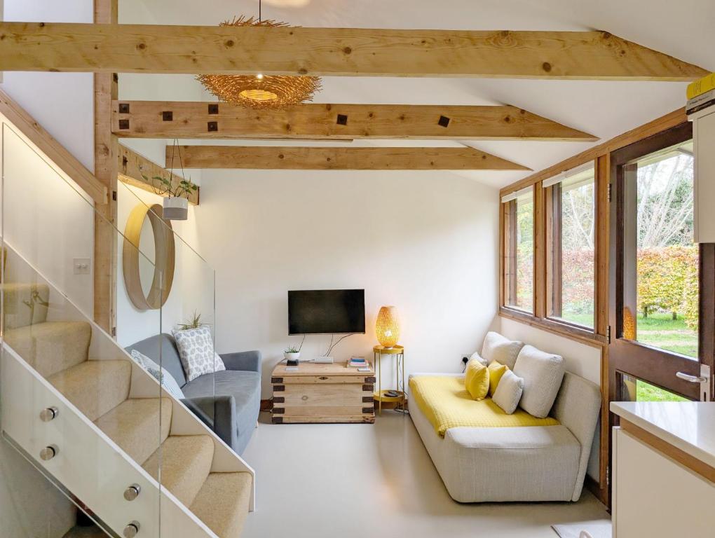 Una pequeña sala de estar con un sofá y un televisor. en The Nest at Severels, en North Mundham