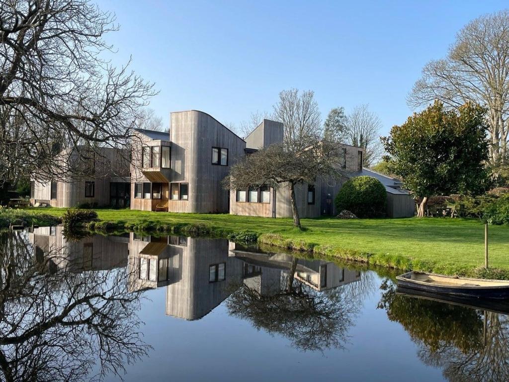 a house with a pond in front of it at The Nest at Severels in North Mundham