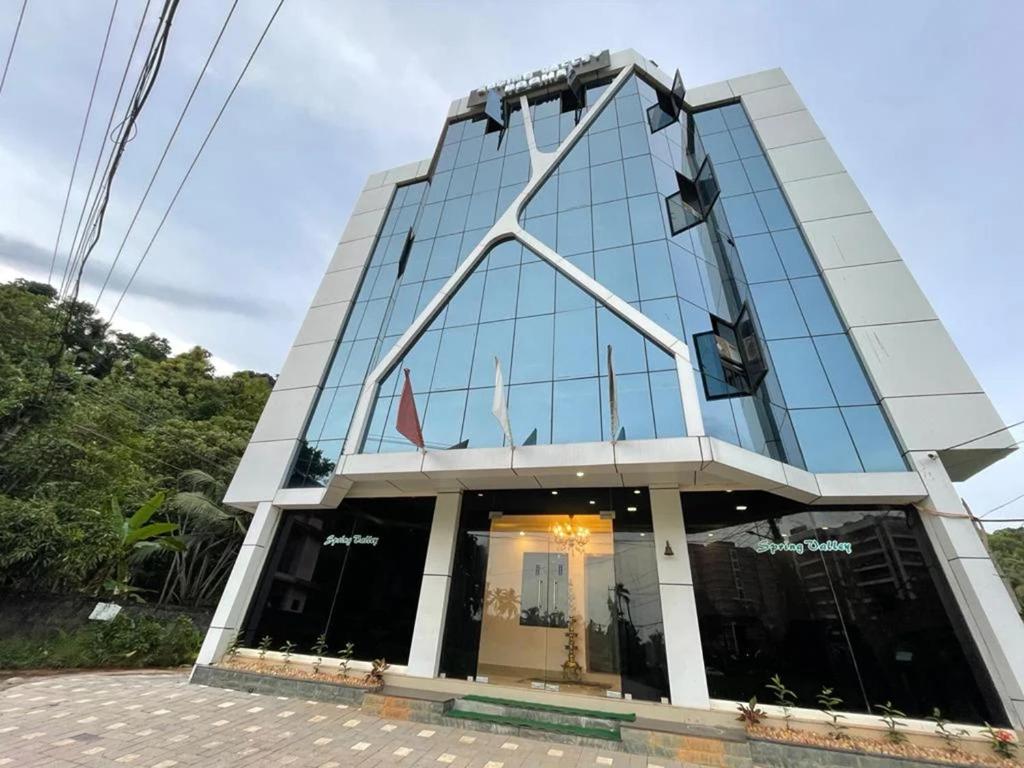 特里凡得琅Spring Valley Hotels next Kims Hospital的一座拥有大型玻璃幕墙的建筑