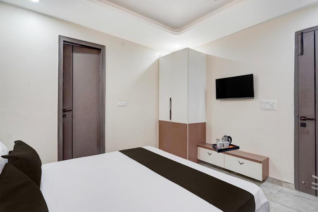 a bedroom with a bed and a tv on the wall at Townhouse DSIDC Bawana Formerly Kanhaiya Residency in Bawāna