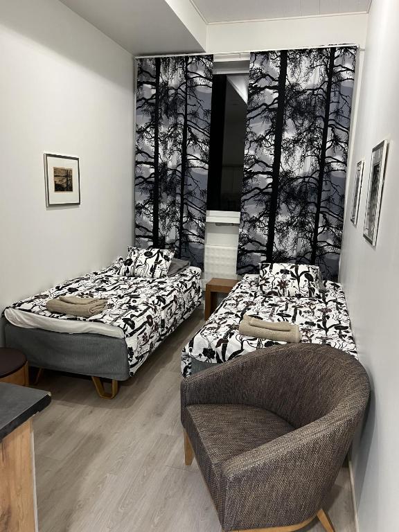 two beds in a room with a chair and a couch at Inari Camping & Resort in Inari