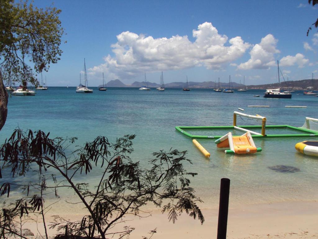 Una vista de una playa con barcos en el agua. en Studio Papaye - confort et calme près des plages, en Sainte-Anne