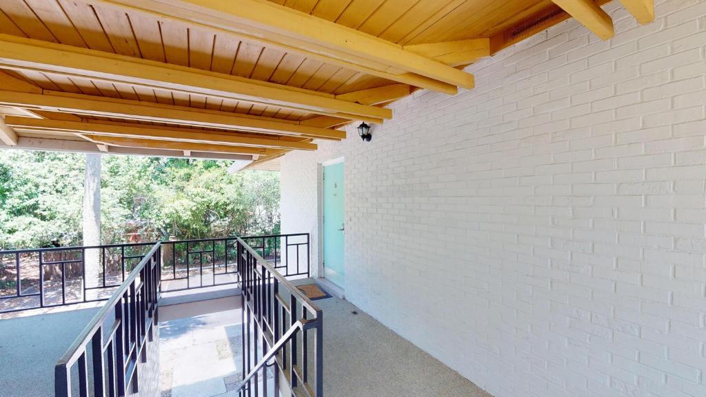 a balcony with white brick walls and a wooden ceiling at Atlantic Breeze #6 in Jekyll Island