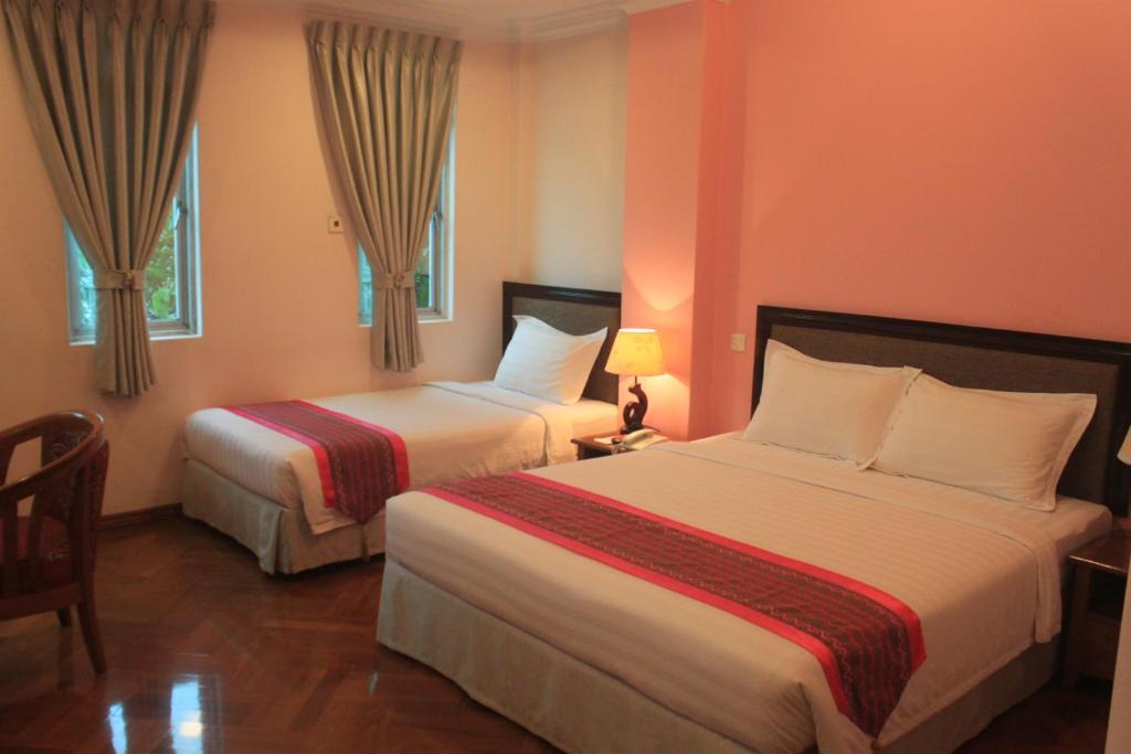 Postel nebo postele na pokoji v ubytování Grand Laurel Hotel