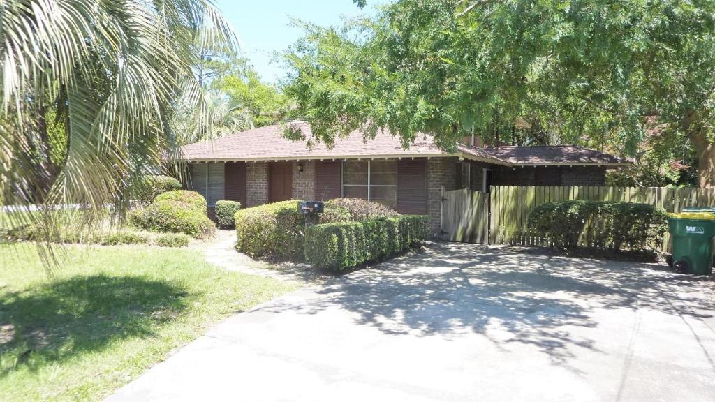 a house with a palm tree and a driveway at Ariel West Duplex in Jekyll Island