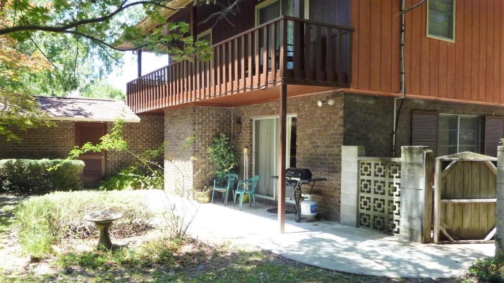 a brick house with a balcony and a patio at Ariel East Duplex in Jekyll Island
