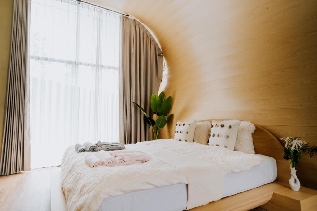 uma cama num quarto com uma grande janela em cithara villa em Kejajar