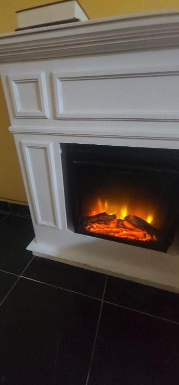 einen weißen Kamin mit einem Feuer darin in der Unterkunft Colibriest Bed & Breakfast in Intibucá