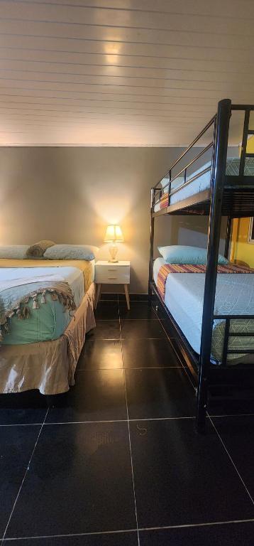 um quarto com 2 beliches e uma mesa com um candeeiro em Colibriest Bed & Breakfast em Intibucá