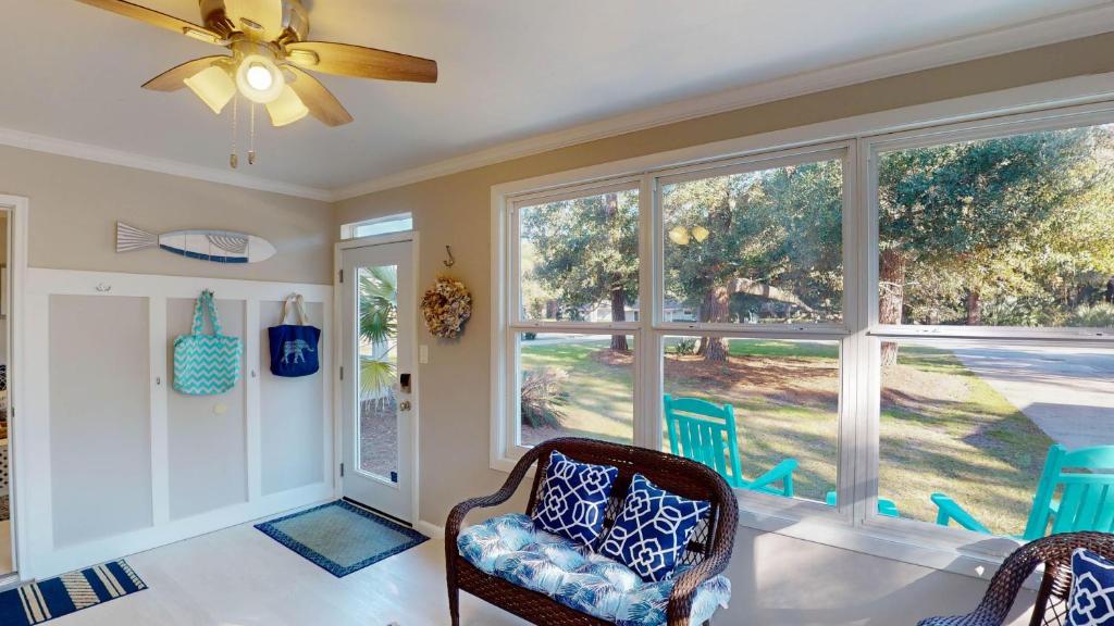 a living room with two chairs and a ceiling fan at Sea Haven Duplex A in Jekyll Island