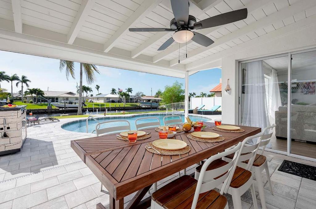 comedor con mesa y piscina en Lovers Key - Waterfront Stunner, Walk to Town!, en Cabo Coral