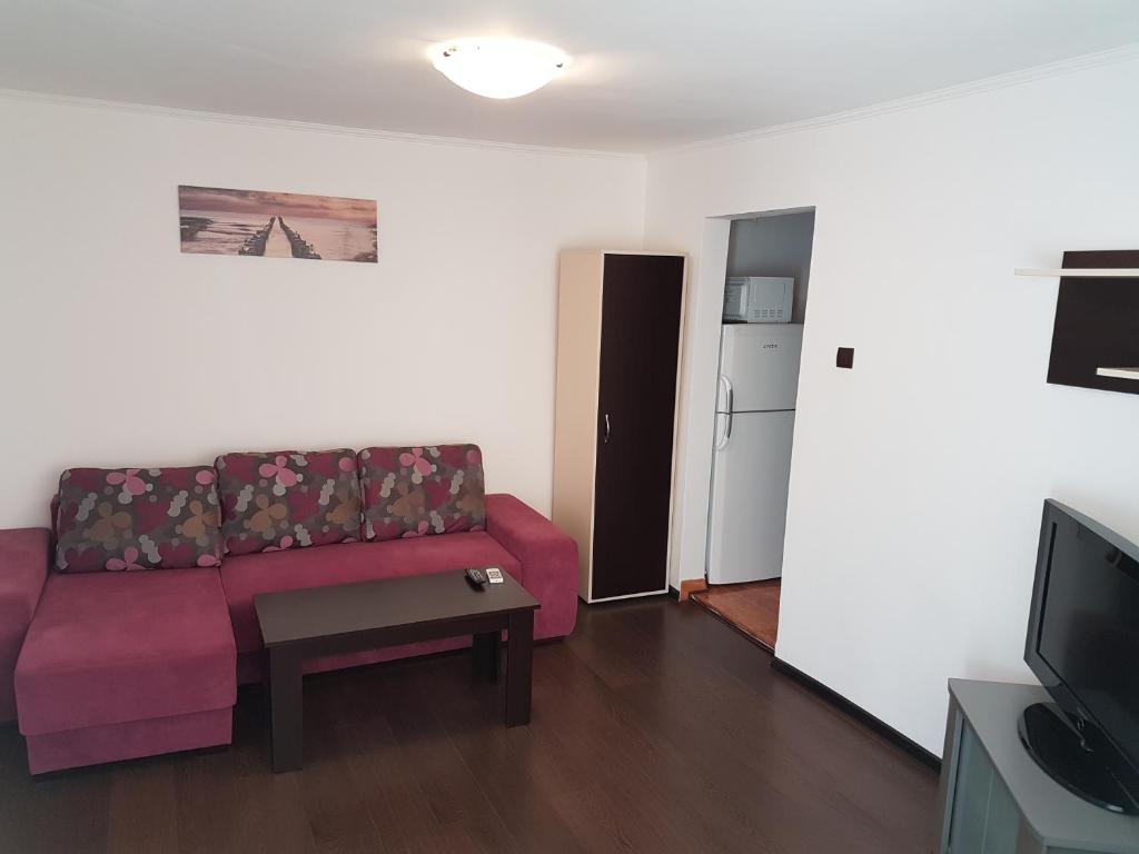 ein Wohnzimmer mit einem Sofa und einem Tisch in der Unterkunft Apartament Tudor in Constanţa