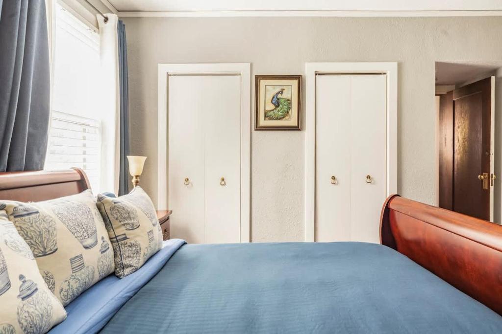une chambre avec un lit avec des draps bleus et une fenêtre dans l'établissement Serene Private Suite Patio Upscale Berkeley, à Piedmont