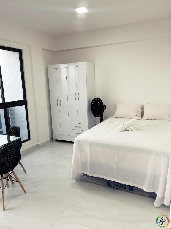 a white bedroom with a bed and a dresser at Compact Time 1402 in Tambaú
