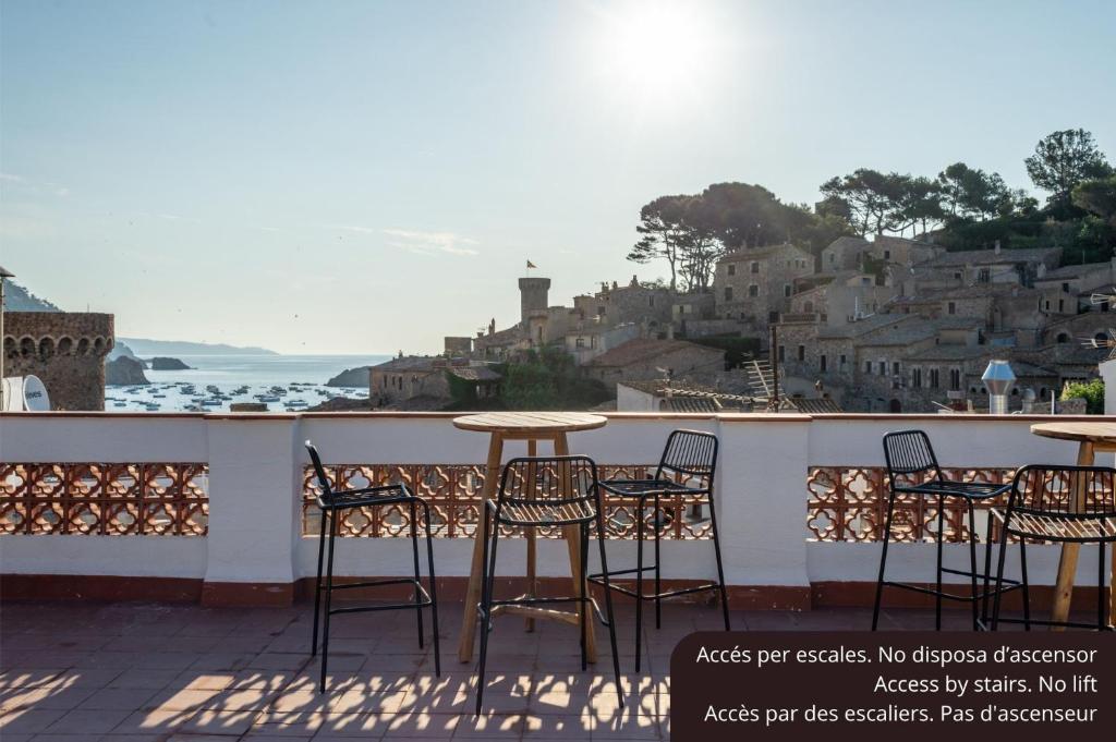 a table and chairs on a balcony with a view of a city at Hostal Boutique Es Menut in Tossa de Mar
