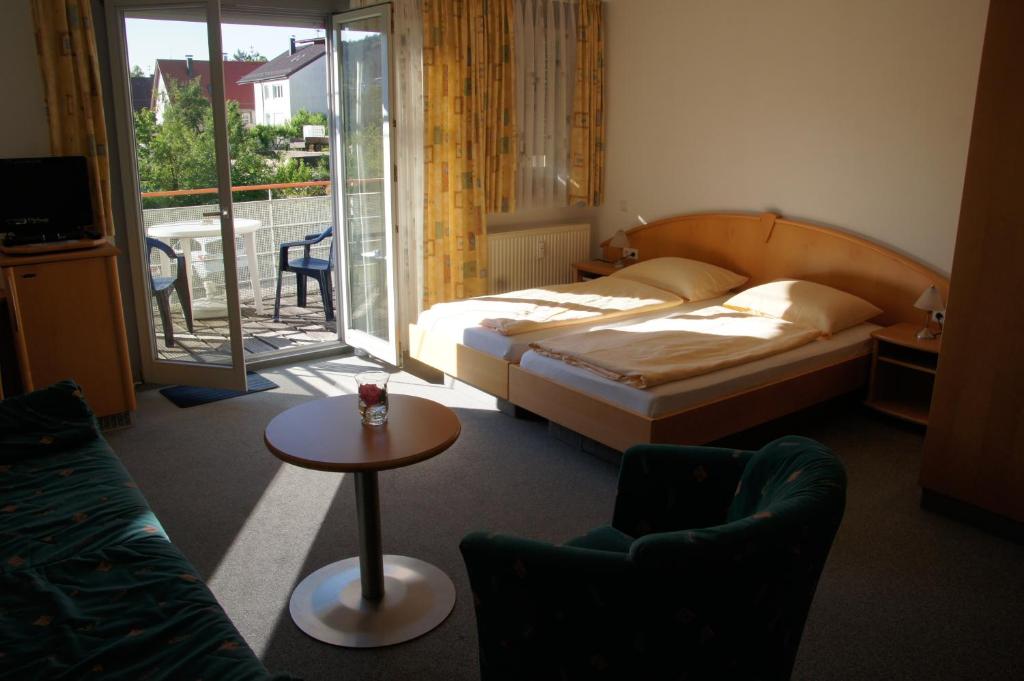 a hotel room with a bed and a table and chairs at Landhaus Heubach in Winnenden