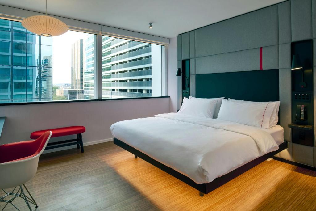 una camera da letto con un letto, una sedia e una finestra di citizenM Austin Downtown ad Austin