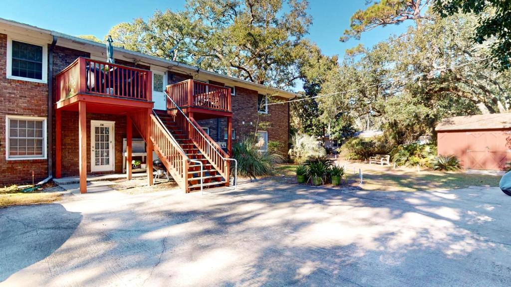 a brick house with a wooden staircase in front of it at Beachbreak in Jekyll Island