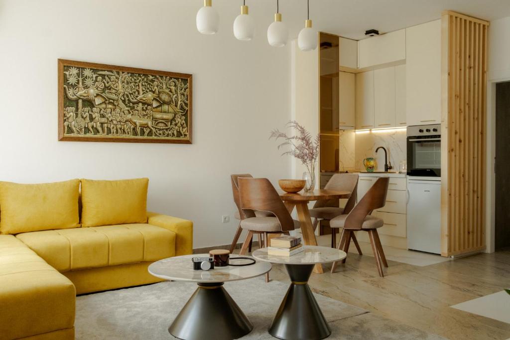 ein Wohnzimmer mit einem gelben Sofa und einem Tisch in der Unterkunft LALA & DAUGHTERS Apartment in Vrnjačka Banja