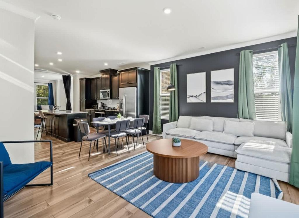ein Wohnzimmer mit einer weißen Couch und einem Tisch in der Unterkunft Luxe King 3BR Townhouse Mins to Uptown CLT in Charlotte